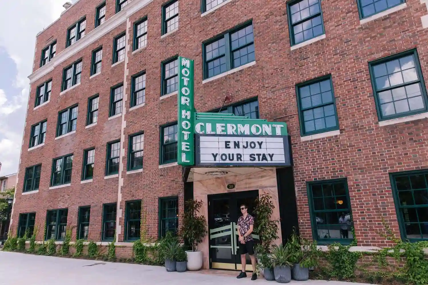 Historic Hotel Clermont on Ponce De Leon Avenue in Atlanta, featuring a vintage marquee, red-brick façade, and iconic rooftop radio tower.​